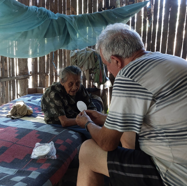 Fary Robero Ábalos llevándole la comunión a una señora enferma de una comunidad nativa (Perú)