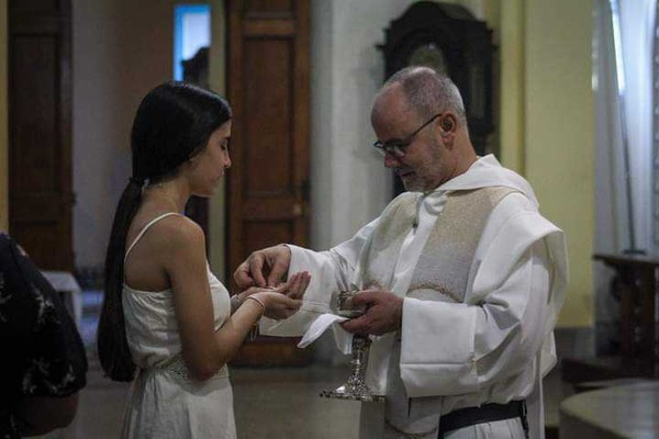 Fr. Celio dando la comunión 97 años Cuba